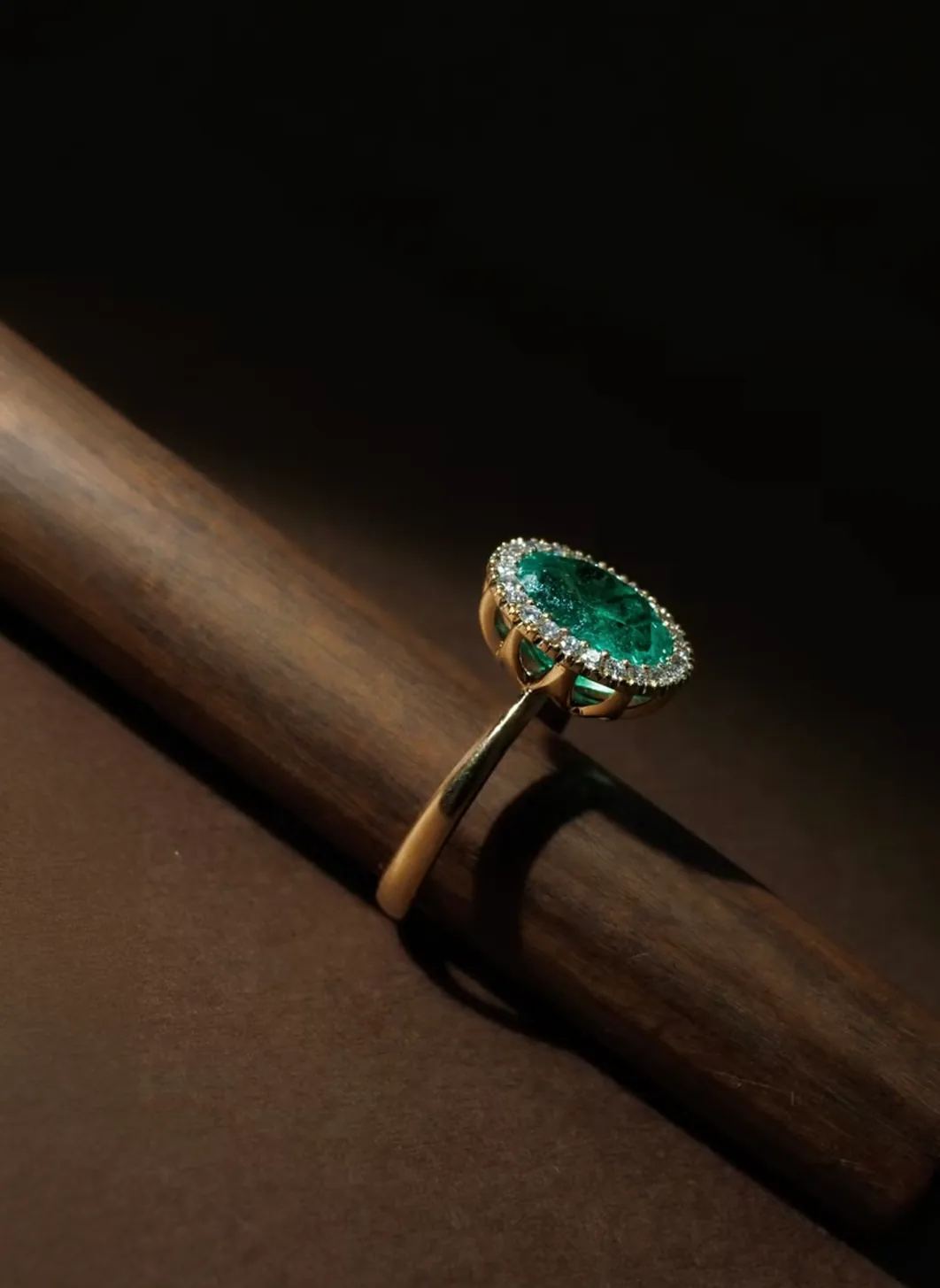 Anillo con esmeralda sobre una pieza de madera